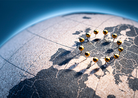 Circle of gold pins on a globe surrounding Europe
