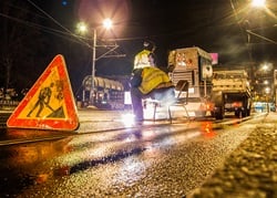 Trucks and worker in street construction
